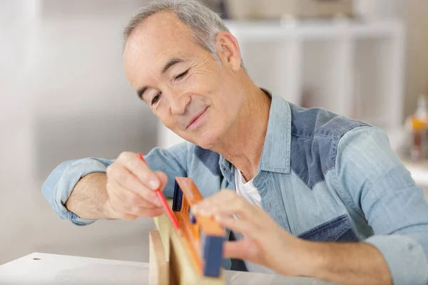 Senior male carpenter using level on wood board — Stock Photo, Image