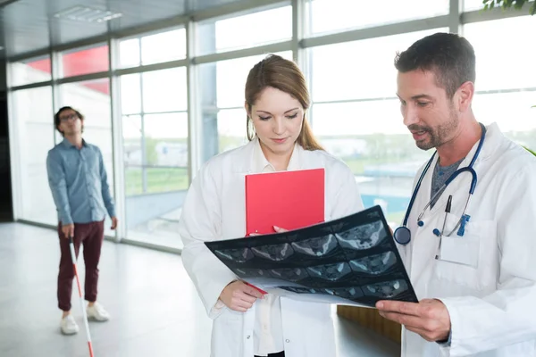 Doctor man en vrouw lezen x-ray film — Stockfoto