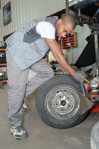 A kereket rögzítő ember a jármű megbontása után — Stock Fotó
