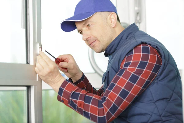 Handwerker befestigt Fenster mit Schraubenzieher — Stockfoto