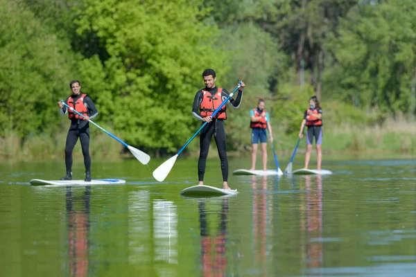 Groupe de personnes debout paddleboard — Photo