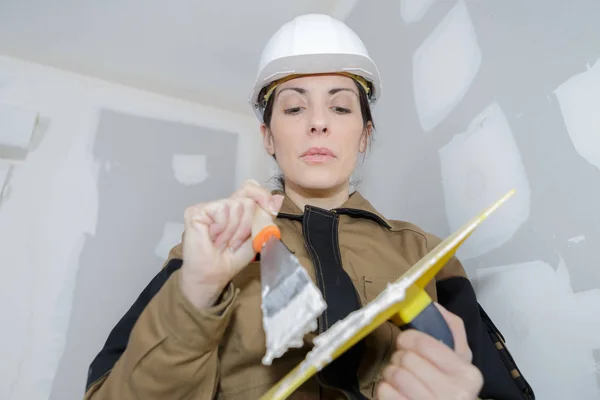Woman plasterer mixing the filler — Stock Photo, Image