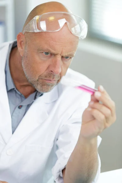 Retrato de primer plano de un investigador masculino sosteniendo un tubo de ensayo — Foto de Stock