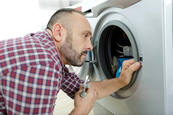 Servicekraft repariert Dichtung an Waschmaschinentür — Stockfoto