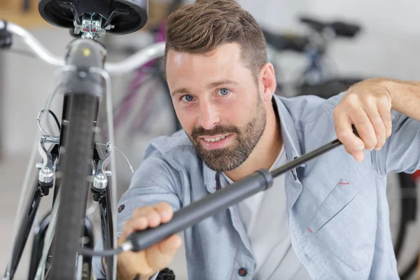 Mann pumpt sein Fahrrad auf, bevor er wegfährt — Stockfoto