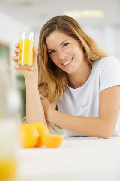 Beautiful young woman with glass of orange juice — Stock Photo, Image