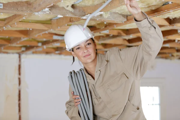 Vrouwelijke elektricien bevestiging plafond verlichting — Stockfoto