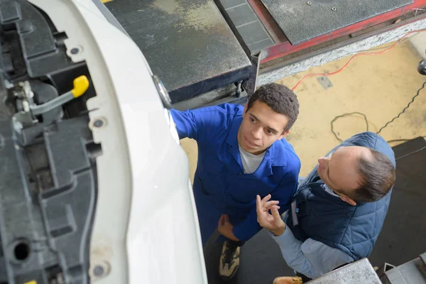 Dois mecânicos reparando um carro — Fotografia de Stock