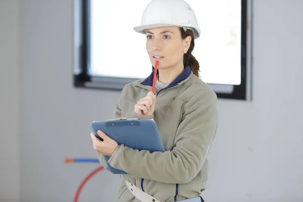 Beautiful woman worker checking notes on clipboard — Stock Photo, Image
