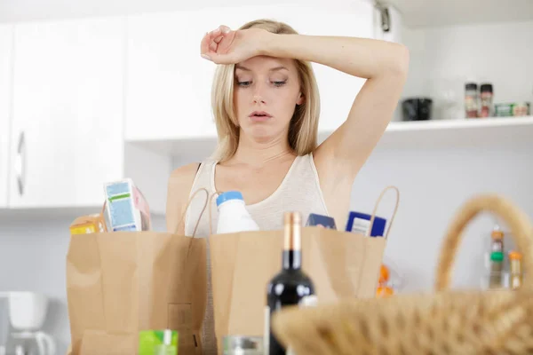 Müde Frau nach Griff nach Tasche mit Lebensmitteln — Stockfoto