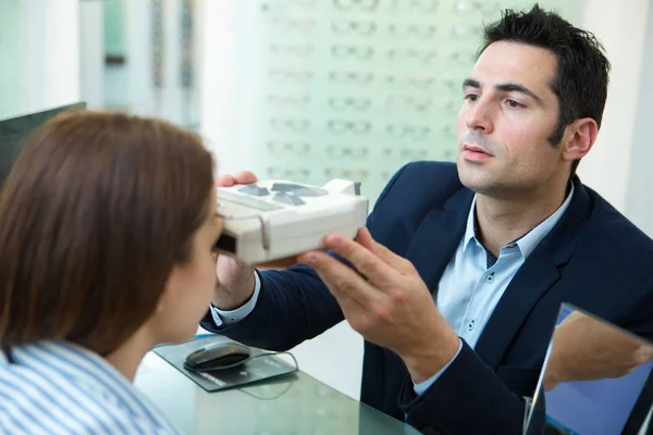 Van een optometrist in examen kamer met vrouw in de stoel — Stockfoto
