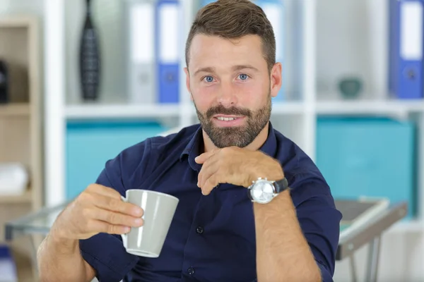Όμορφος άνθρωπος που κατέχει ένα φλυτζάνι του καφέ — Φωτογραφία Αρχείου