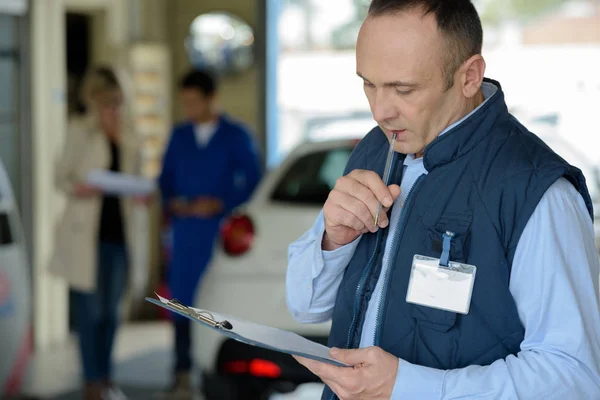 Male manager with clipboard at car repair service — Stock Photo, Image