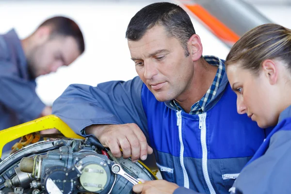 Equipe mecânica masculina e feminina examinar o motor do carro — Fotografia de Stock