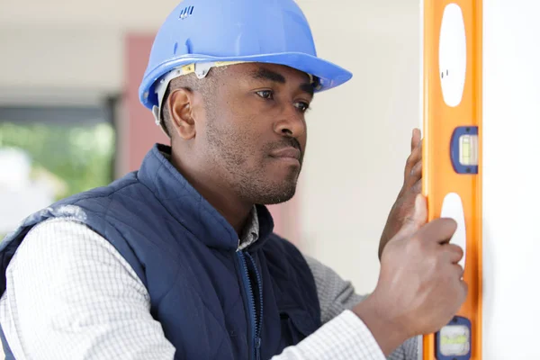 Male builder using spirit level — Stock Photo, Image