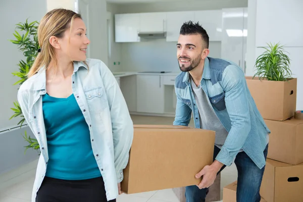 Casal transportando caixa de papelão no novo apartamento — Fotografia de Stock