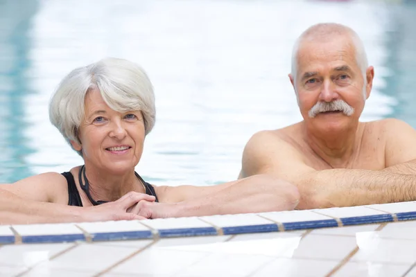 Feliz pareja de ancianos en la piscina —  Fotos de Stock