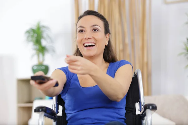 Mujer alegre viendo la televisión en la sala de estar — Foto de Stock