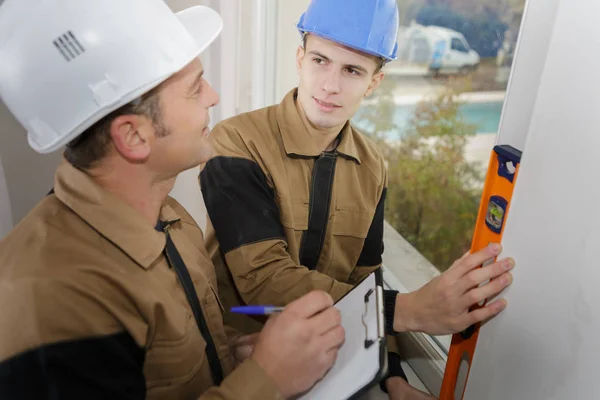 Retrato de construtor com nível de espírito com mentor — Fotografia de Stock