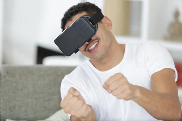 Giovane uomo guida in realtà virtuale indossando cuffie futuristiche vr — Foto Stock