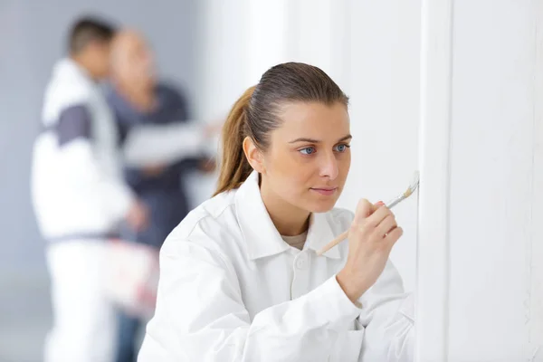 Woman painting the wall edge with brush — Stock Photo, Image