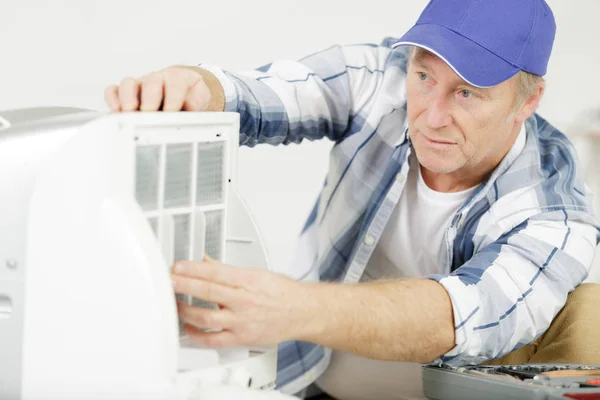 Homme mûr se préparant à installer un nouveau climatiseur — Photo