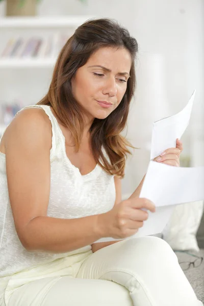 Mujer joven conmocionada leyendo carta en casa — Foto de Stock