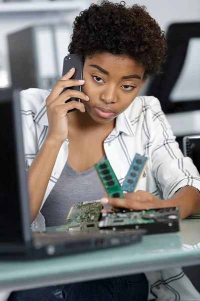 Frau am Telefon repariert einen PC — Stockfoto