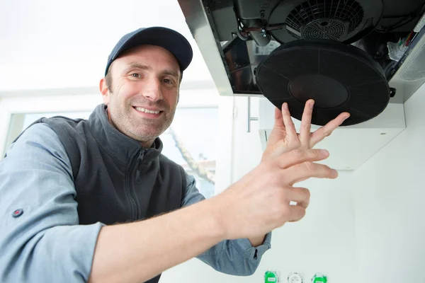 Portrait of man changing filter in kitchen extractor hood — Stock Photo, Image