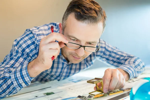 Werknemer in een afdruk gebruikt een vergrootglas — Stockfoto