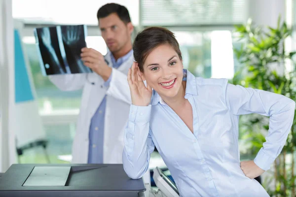 Doctor houden röntgenfoto beeld terwijl de patiënt kijkt naar camera — Stockfoto