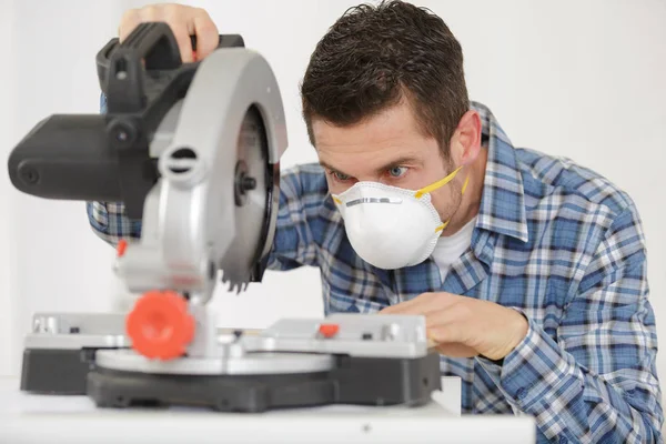 Man die cirkelzaag binnenshuis gebruikt — Stockfoto