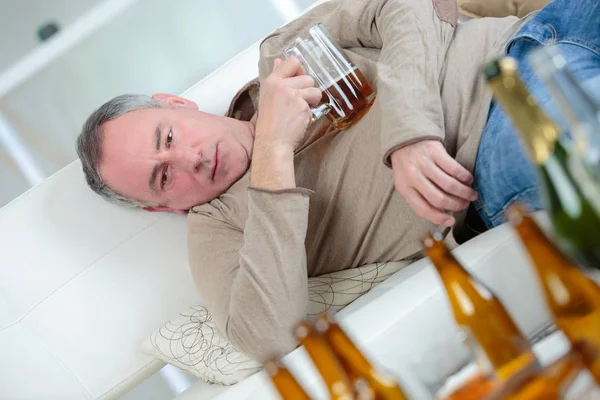 Uomo alcolizzato svegliarsi guardando le bottiglie — Foto Stock