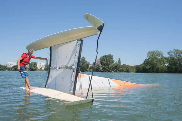 Salior trying to right his catamaran after capsize — Stock Photo, Image