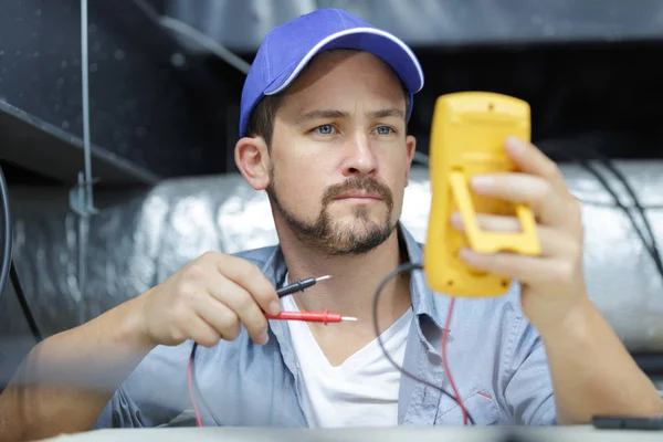Чоловічий технік ремонтує промисловий кондиціонер в приміщенні — стокове фото
