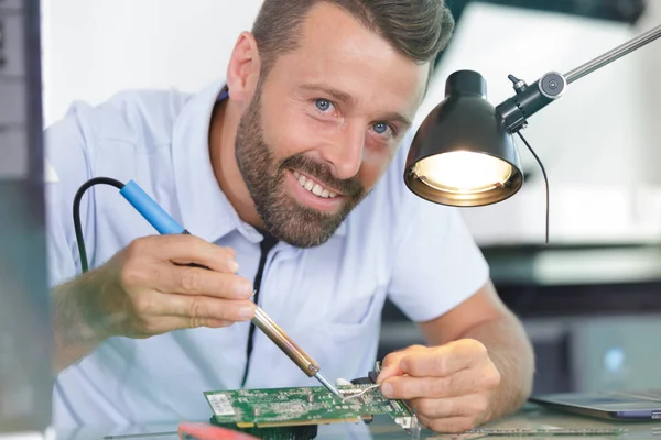 Homem testando placa de circuito em seu escritório — Fotografia de Stock
