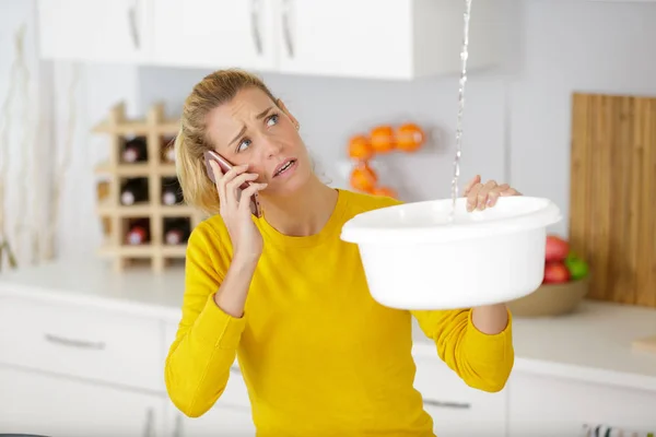 Femme appelant le plombier pour problème de fuite d'eau — Photo