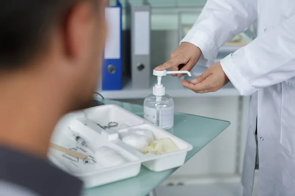 Médico bombeando desinfectante en la mano desde el dispensador —  Fotos de Stock
