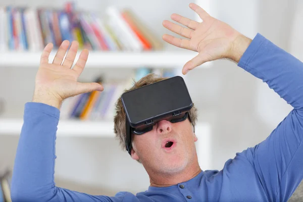 Hombre con los brazos de auriculares de realidad virtual levantados en el aire —  Fotos de Stock