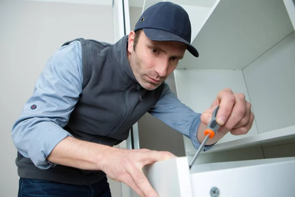 Workman Fixing keuken lade met schroevendraaier — Stockfoto