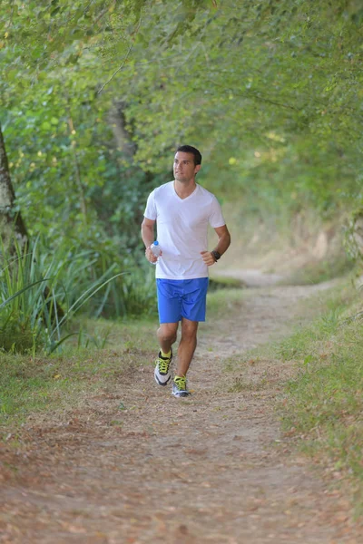 Hombre corriendo a lo largo del camino del país — Foto de Stock