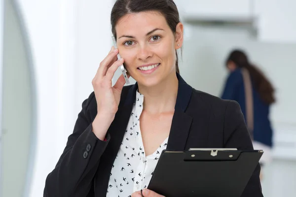 Atractiva joven empresaria con portapapeles — Foto de Stock