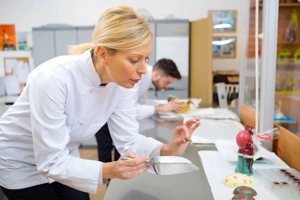 Worker dekorera choklad plack i köket — Stockfoto