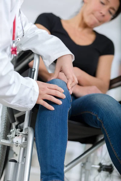 Médico ortopédico masculino examinando mulheres joelho na clínica — Fotografia de Stock