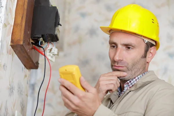 Elettricista tecnico al lavoro su un quadro elettrico residenziale — Foto Stock