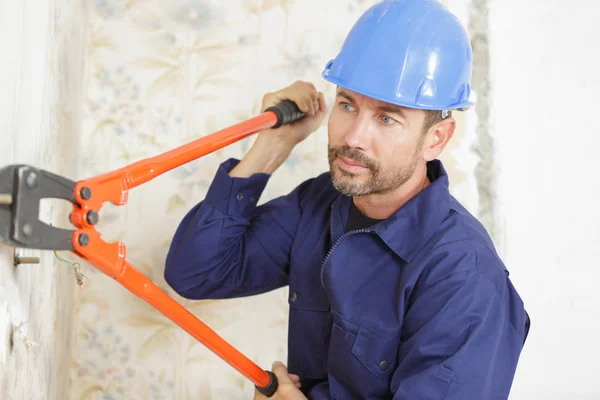 Workman with scissors mower indoors — Stock Photo, Image