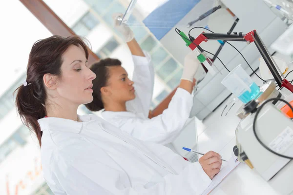 Cientista feminina no laboratório que trabalha no tablet — Fotografia de Stock