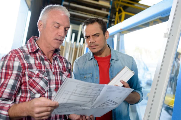 Mannelijke supervisor die de kwaliteit van afgewerkt PVC raamkozijn controleert — Stockfoto