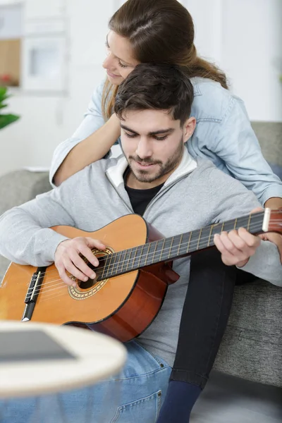 Любимая пара с гитарой в комнате дома — стоковое фото