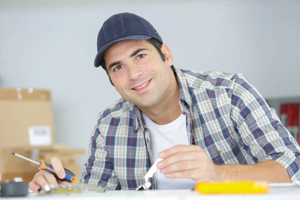 Hombre feliz la fijación de la puerta con destornillador — Foto de Stock